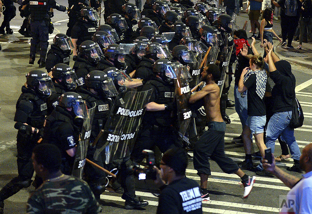  Charlotte-Mecklenburg police officers begin to move protesters down a street in Charlotte, N.C., on Sept. 21, 2016. Authorities in Charlotte tried to quell public anger after a police officer shot a black man, but a dusk prayer vigil turned into a s