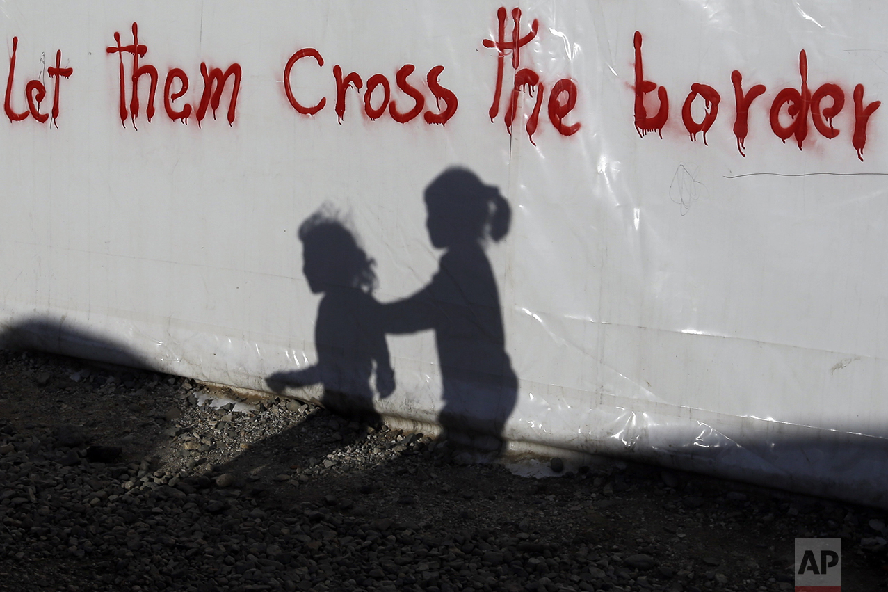 Shadows of children are cast on a tent bearing graffiti at the northern Greek border point of Idomeni, Greece, on May 4, 2016. (AP Photo/Gregorio Borgia) 