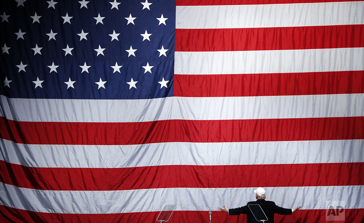  Republican presidential candidate Donald Trump turns to the American flag at a campaign rally in Sterling Heights, Mich., on Nov. 6, 2016. (AP Photo/Paul Sancya) 