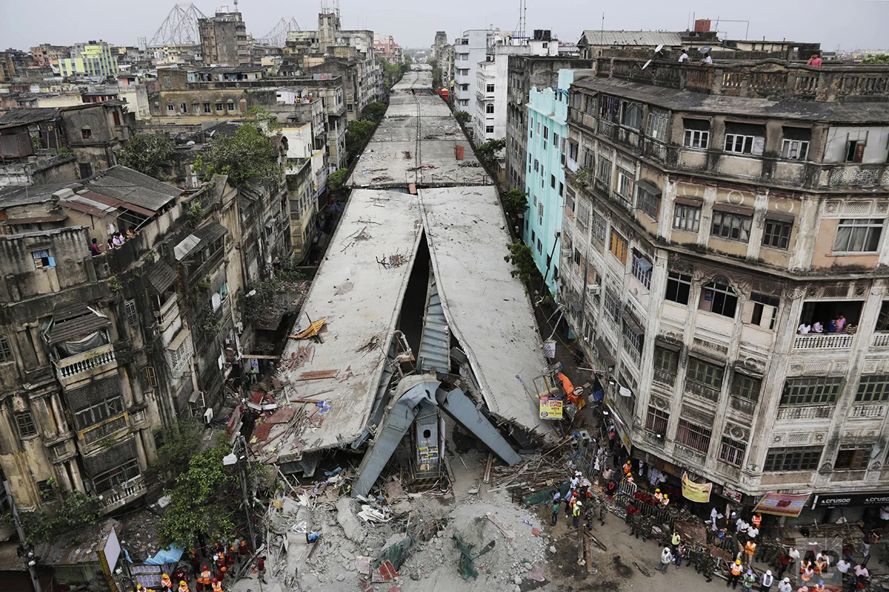 This April 1, 2016 photo shows a partially collapsed overpass in Kolkata, India. The overpass spanned nearly the width of the street and was designed to ease traffic through the densely crowded Bara Bazaar neighborhood in the capital of the east Indian state of West Bengal. About 100 meters (300 feet) of the overpass fell, while other sections remained standing. (AP Photo/Bikas Das)