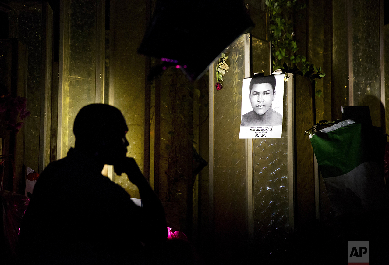  A visitor to the Muhammad Ali Center in Louisville, Ky., looks at an image of the great boxer posted on a makeshift memorial on June 9, 2016. Ali, born Cassius Clay, died on June 3 at age 74. (AP Photo/David Goldman) 