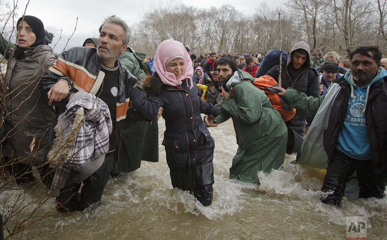  A woman cries as she crosses the river along with other migrants, north of Idomeni, Greece, attempting to reach Macedonia on a route that would bypass the border fence, on March 14, 2016. (AP Photo/Vadim Ghirda) 