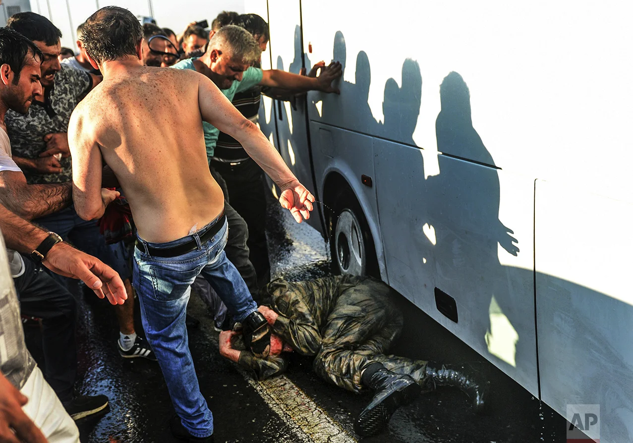 People kick and beat a Turkish soldier that participated in an attempted coup, on Istanbul's Bosporus Bridge, on July 16, 2016. Turkish President Recep Tayyip Erdogan told the nation that his government was working to crush a coup attempt after a night of explosions, air battles and gunfire across the capital that left dozens dead and scores wounded. (AP Photo/Selcuk Samiloglu)