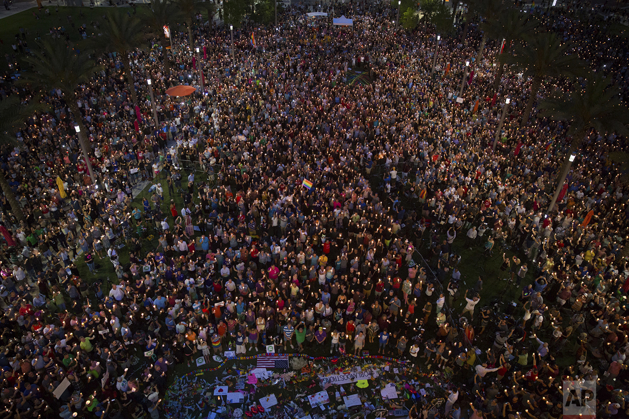  Mourners attend a candlelight vigil in front of the Dr. P. Phillips Center for the Performing Arts in downtown Orlando, Fla., on June 13, 2016, the day after an attack on a gay nightclub left dozens dead. (Loren Elliott/Tampa Bay Times via AP) 