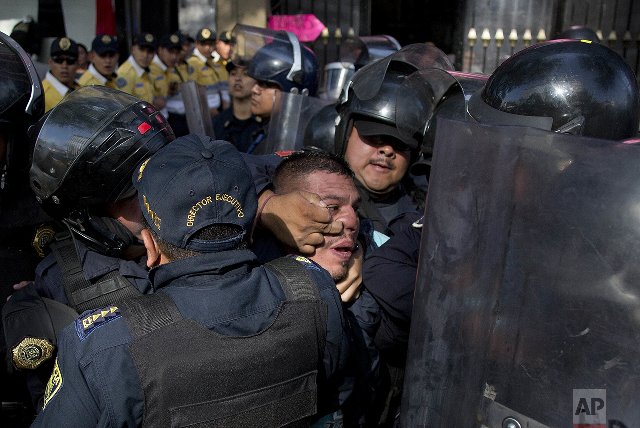  Police detain a taxi driver who, along with other cabbies, blocked a main road to protest the one day per week driving restriction in Mexico City on April 13, 2016. Under new regulations imposed after the capital experienced its worst air-quality cr