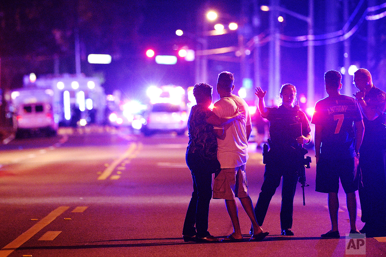  Orlando Police officers direct family members away from a fatal shooting at Pulse nightclub in Orlando, Fla., on June 12, 2016. Omar Mateen, a 29-year-old security guard, killed 49 people and wounded 53 others in the mass shooting. (AP Photo/Phelan 