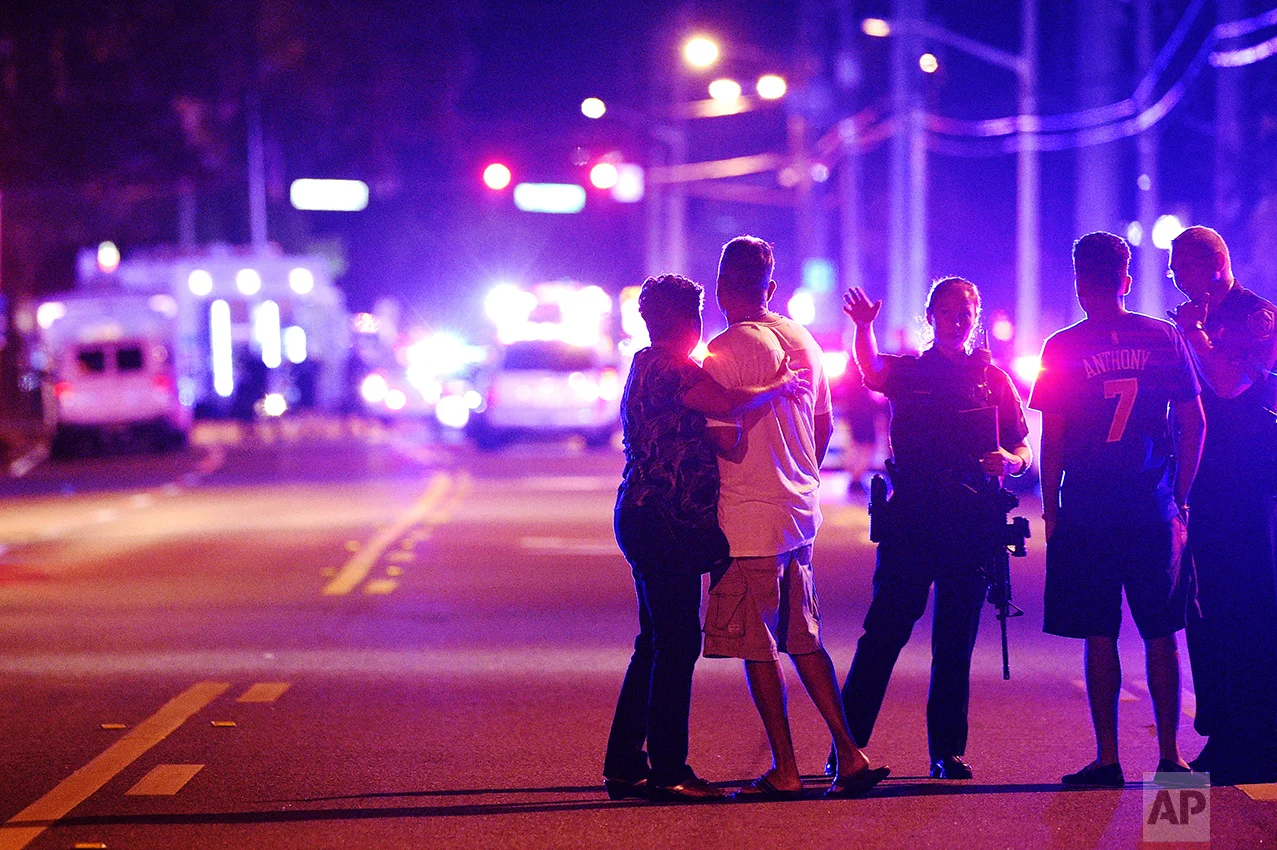 Orlando Police officers direct family members away from a fatal shooting at Pulse nightclub in Orlando, Fla., on June 12, 2016. Omar Mateen, a 29-year-old security guard, killed 49 people and wounded 53 others in the mass shooting. (AP Photo/Phelan M. Ebenhack)