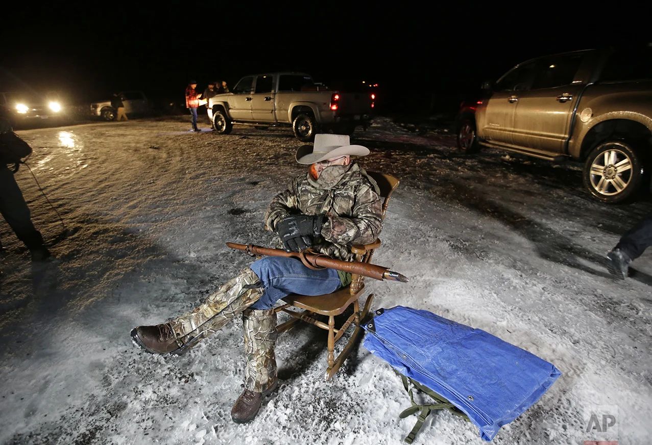 Arizona rancher LaVoy Finicum holds a gun as he guards the Malheur National Wildlife Refuge near Burns, Ore., on Jan. 5, 2016. Ammon Bundy, the leader of a small, armed group occupying the remote national wildlife preserve said earlier in the day that they will go home when a plan is in place to turn over management of federal lands to locals. (AP Photo/Rick Bowmer)