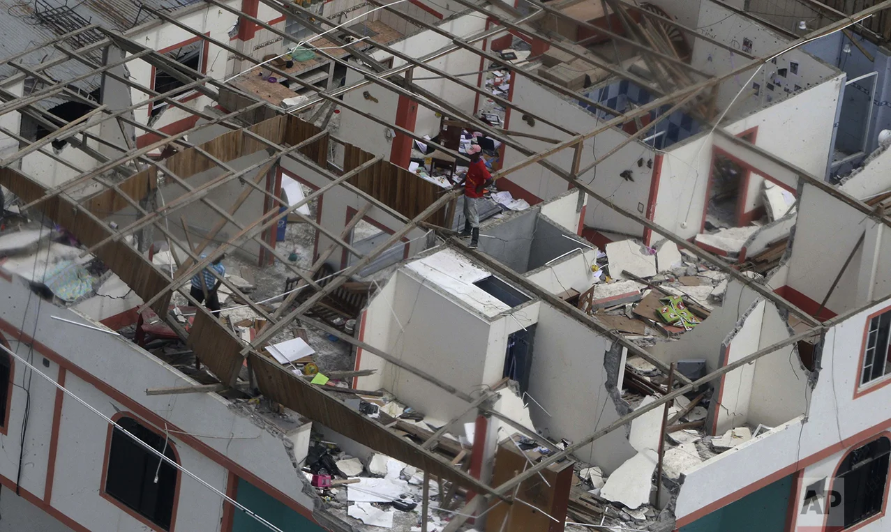 A man stands on an earthquake-damaged building in Pedernales, Ecuador, on April 20, 2016. It was the country's deadliest earthquake in decades. (AP Photo/Dolores Ochoa)