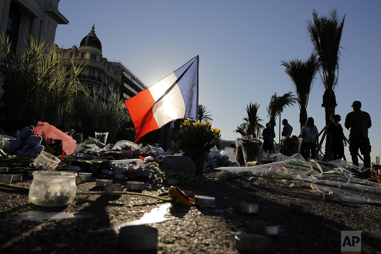  A French flag stands tall within a floral tribute for the victims killed during a deadly attack on the famed Boulevard des Anglais in Nice, southern France, on July 17, 2016. (AP Photo/Laurent Cipriani) 