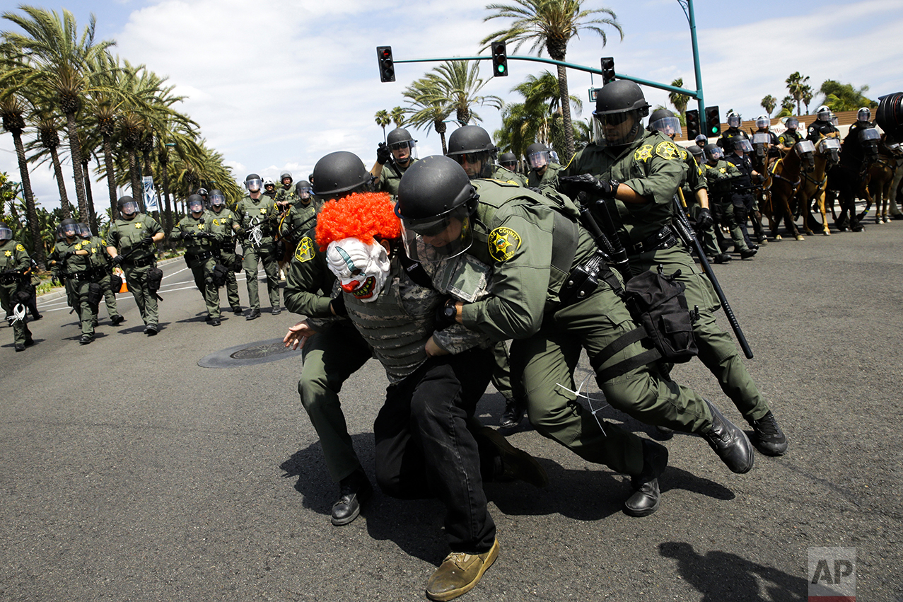  Orange County Sheriff's deputies take a protester into custody outside the Anaheim Convention Center where Republican presidential candidate Donald Trump is holding a rally, on May 25, 2016, in Anaheim, Calif. (AP Photo/Jae C. Hong) 