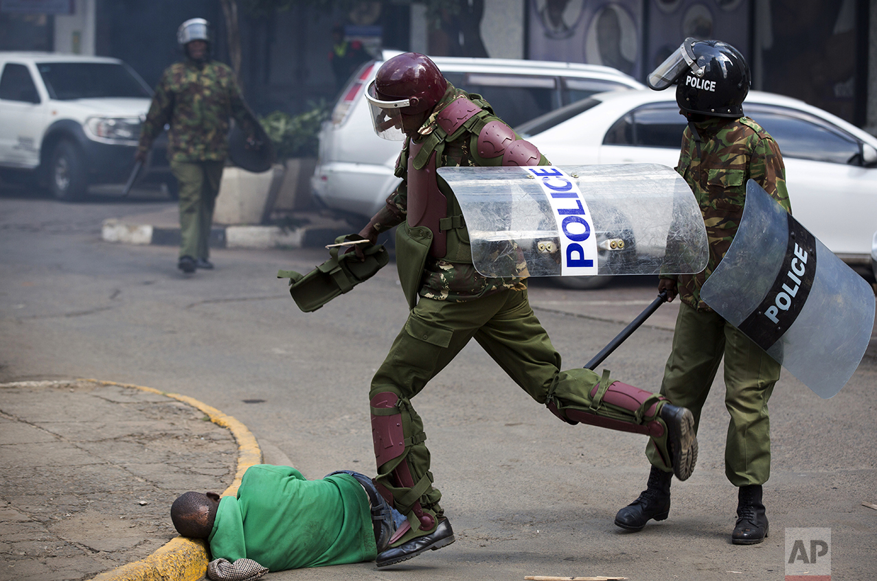  A Kenyan riot policeman repeatedly kicks a protester who lies in the street after tripping over while trying to flee from them, during a protest in downtown Nairobi, Kenya, on May 16, 2016. Kenyan police tear-gassed and beat opposition supporters du