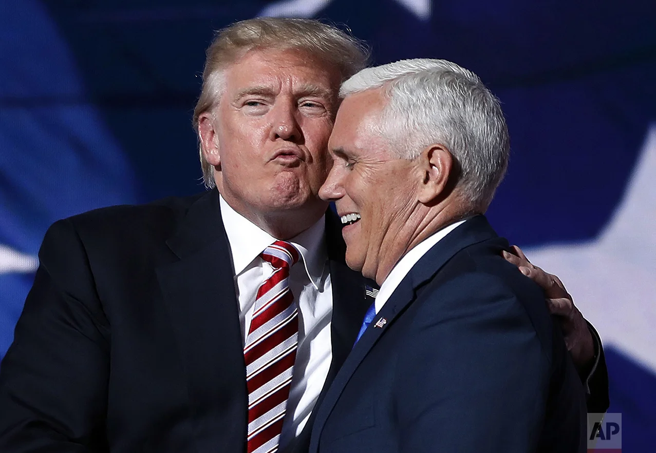 Republican presidential Candidate Donald Trump gives his running mate, Gov. Mike Pence of Indiana, a kiss as they shake hands after Pence's acceptance speech to be the vice presidential nominee during the third day session of the Republican National Convention in Cleveland, on July 20, 2016. (AP Photo/Mary Altaffer)