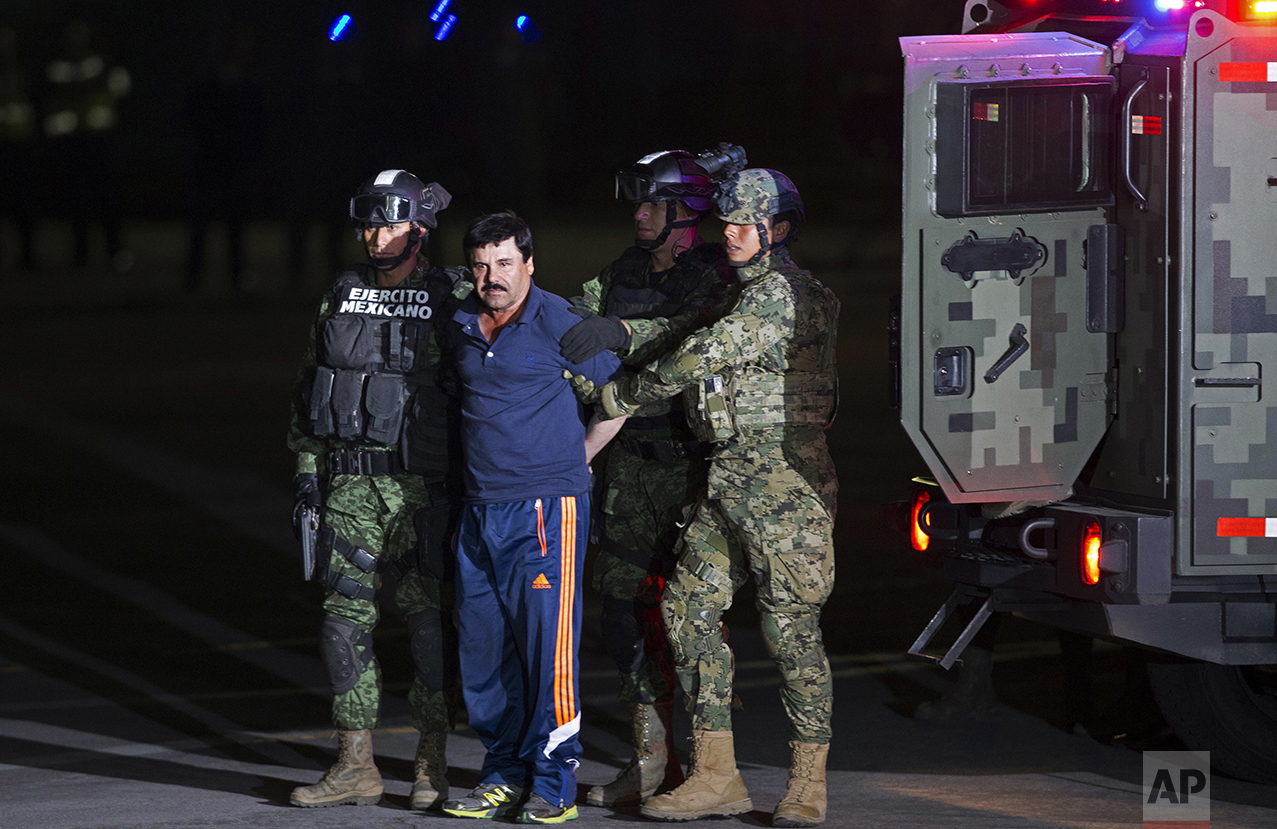  Mexican army soldiers escort drug lord Joaquin "El Chapo" Guzman to a helicopter to be transported to a maximum security prison at Mexico's Attorney General's hangar, in Mexico City, on Jan. 8, 2016. The world's most-wanted drug lord was captured fo