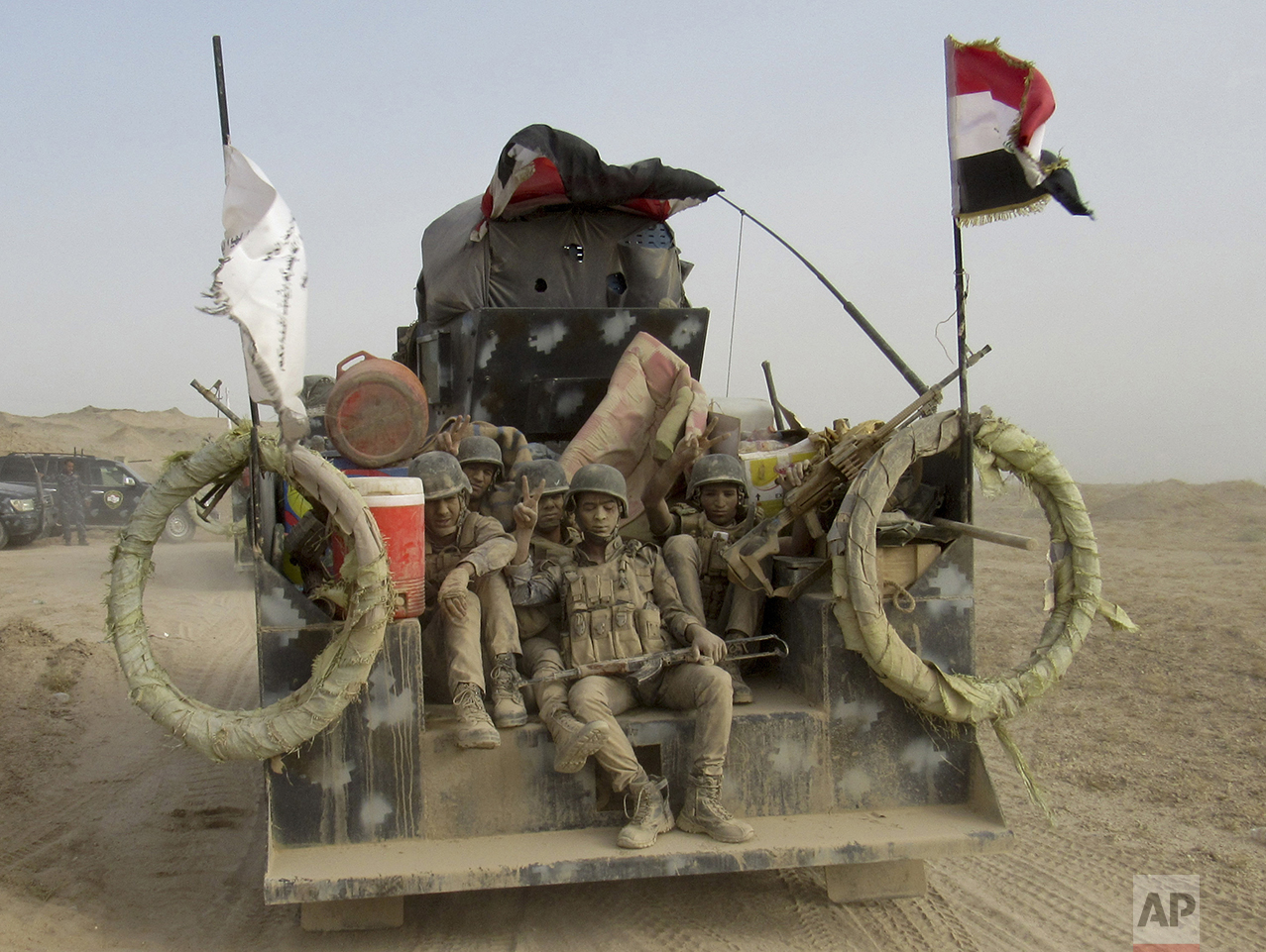  Iraqi Federal police covered in dust arrive to join the forces surrounding Fallujah, 40 miles (65 kilometers) west of Baghdad, Iraq, on May 24, 2016. (AP Photo/Rwa Faisal) 