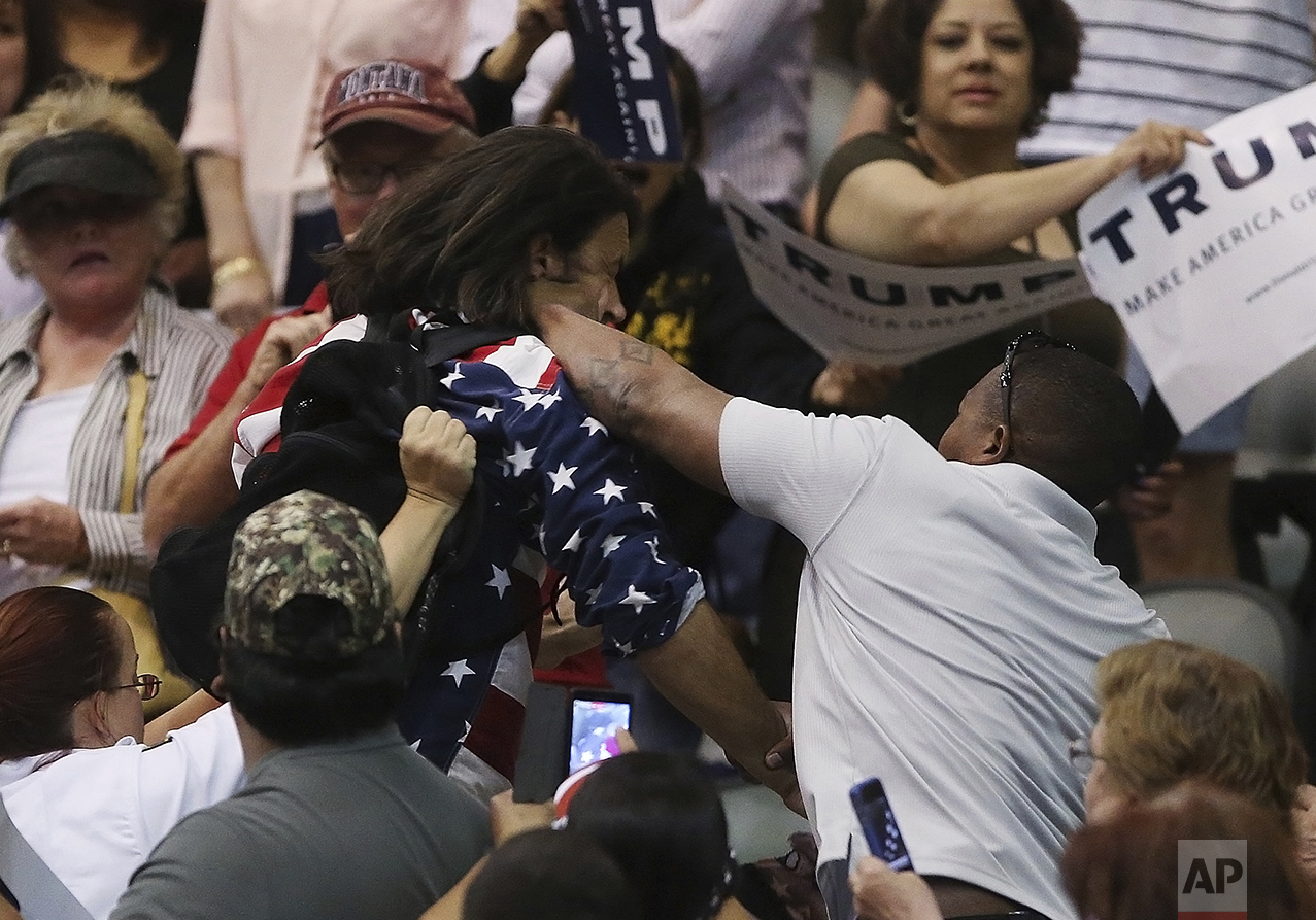  Anti-Trump protester Bryan Sanders, center left, is punched by a Trump supporter as he is escorted out of Republican presidential candidate Donald Trump's rally in Tucson, Ariz., on March 19, 2016. (Mike Christy/Arizona Daily Star via AP) 