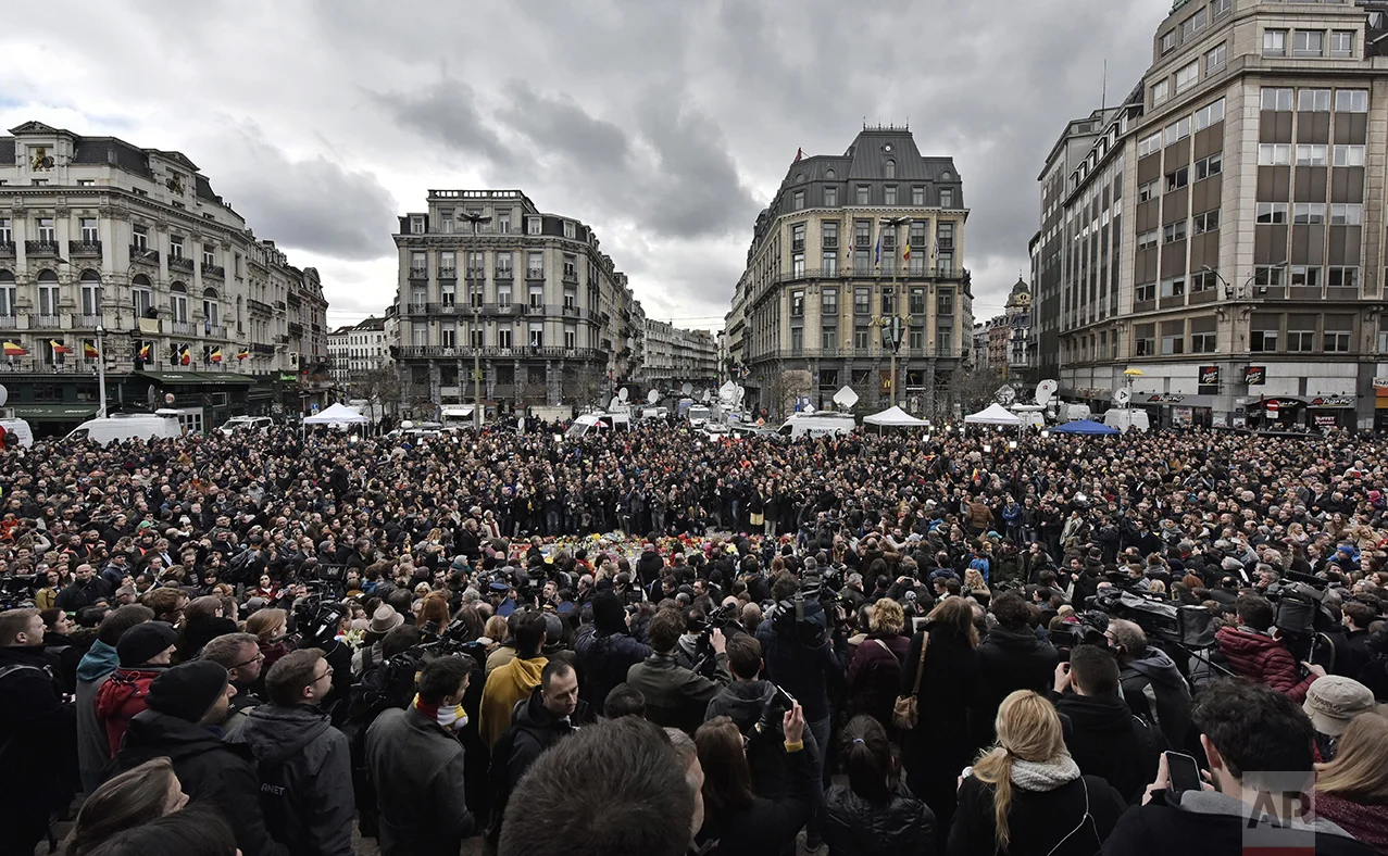 People observe a minute of silence at the Place de la Bourse in the center of Brussels, on March 23, 2016. Bombs exploded the day before at the Brussels airport and one of the city's metro stations killing and wounding scores of people, as a European capital was again locked down amid heightened security threats. (AP Photo/Martin Meissner)