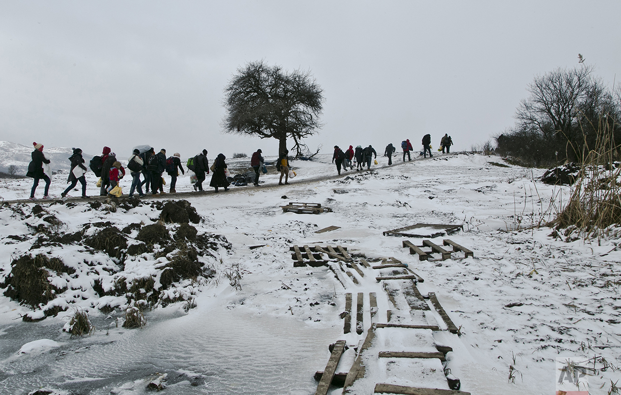  Migrants walk through a snow storm across a frozen stream after crossing the border from Macedonia into Serbia, near the village of Miratovac, Serbia, on Jan. 18, 2016. (AP Photo/Visar Kryeziu) 