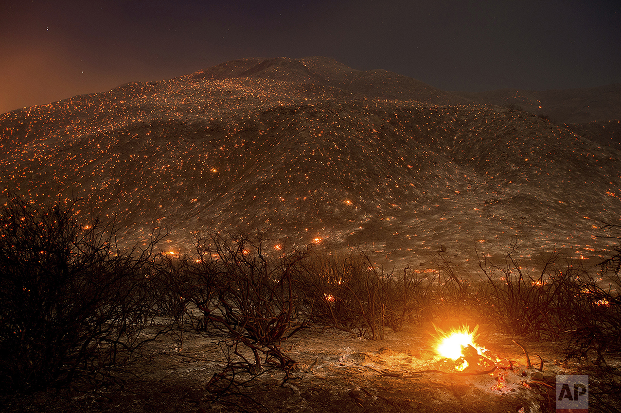  Embers from a wildfire smolder along Lytle Creek Road near Keenbrook, Calif., on Aug. 17, 2016. (AP Photo/Noah Berger) 