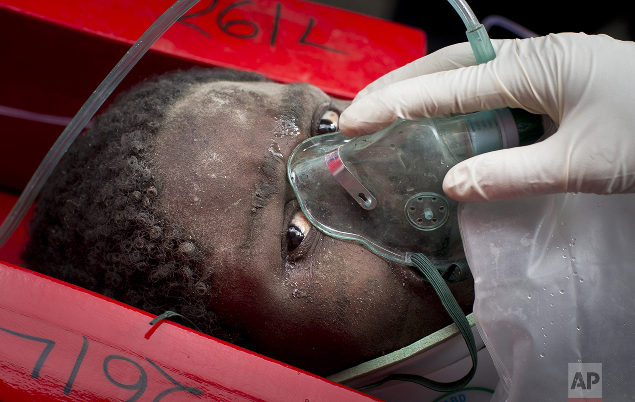  A woman is carried away in a stretcher by medics after being trapped for six days in the rubble of a collapsed building in the Huruma area of Nairobi, Kenya, on May 5, 2016. After discovering the woman alive and conscious, rescuers administered an I