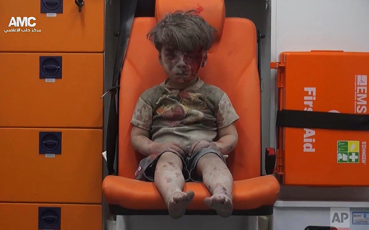  In this frame grab taken from video provided by the Syrian anti-government activist group Aleppo Media Center (AMC), 5-year-old Omran Daqneesh sits in an ambulance after being pulled out of a building hit by an airstrike in Aleppo, Syria, on Aug. 17