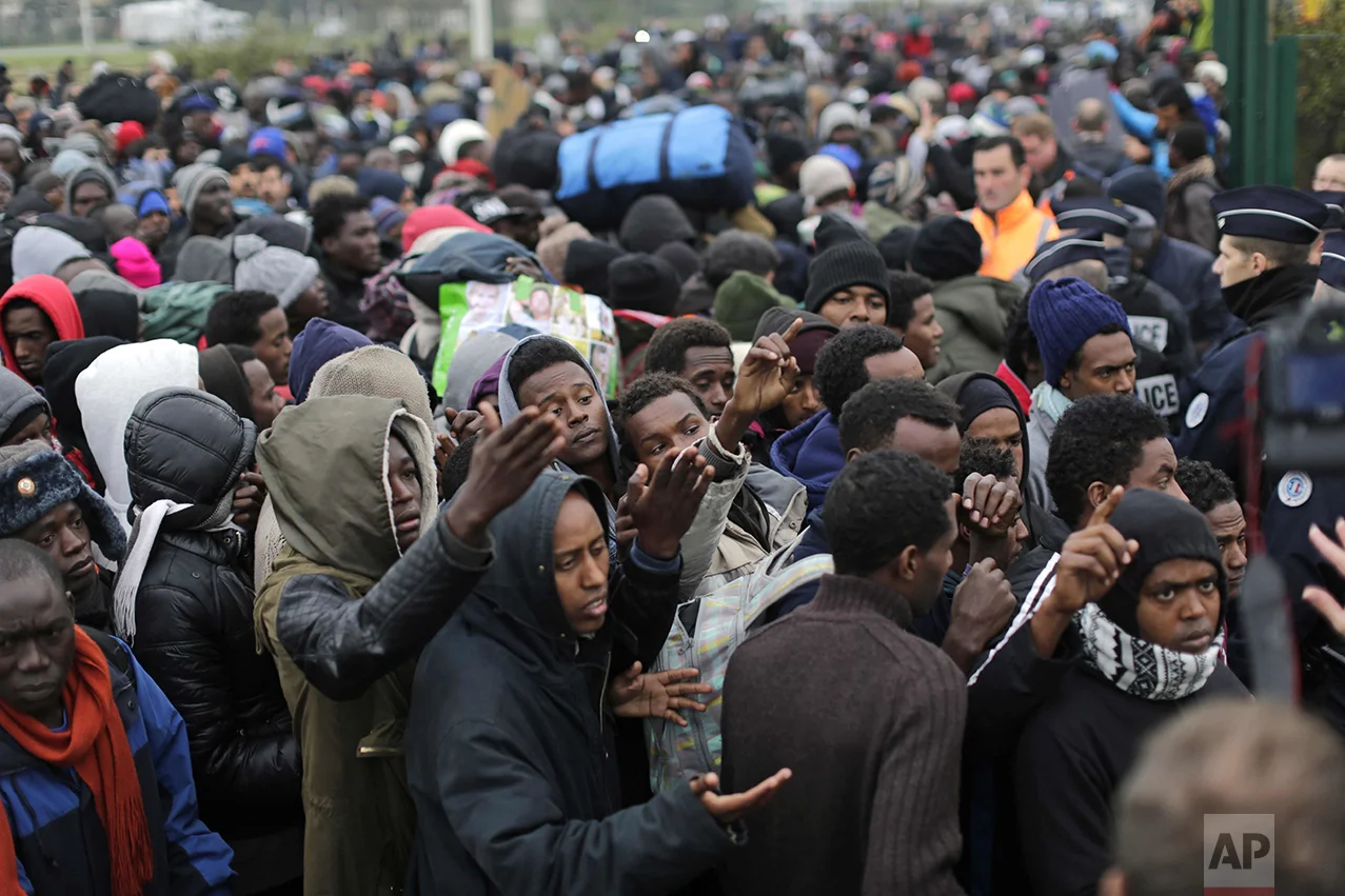 Migrants line-up to register at a processing center in the makeshift migrant camp known as "the jungle" near Calais, northern France, on Oct. 24, 2016. The French evacuated 6,400 migrants from the encampment in 170 buses, starting on Oct. 24, with the intent of resettling them in different regions of France. On Oct. 26 French authorities announced that the camp had been cleared. (AP Photo/Emilio Morenatti)
