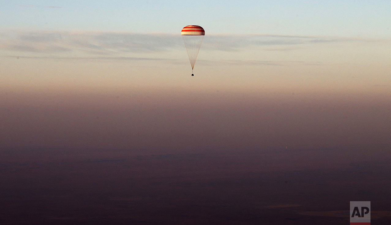 The Soyuz TMA-19M capsule carrying NASA's Jeff Williams, and Russian cosmonauts Alexey Ovchinin and Oleg Skripochka descends beneath a parachute near the town of Zhezkazgan, Kazakhstan, on Sept. 7, 2016. The record-setting American and two Russians landed safely back on Earth after a six-month mission aboard the International Space Station. (Maxim Shipenkov/Pool Photo via AP)