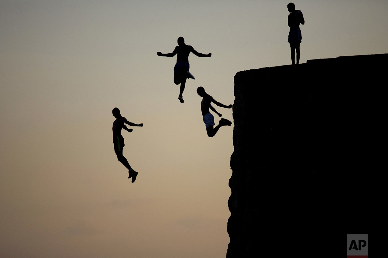 Israeli Arab boys jump into the Mediterranean sea from the ancient wall surrounding the old city of Acre, northern Israel, on Aug. 2, 2016. (AP Photo/Ariel Schalit)
