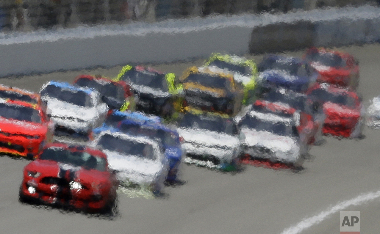 Heat waves distort this image of drivers following the pace car during the NASCAR Xfinity series auto race at Michigan International Speedway, on June 11, 2016, in Brooklyn, Mich. (AP Photo/Carlos Osorio)