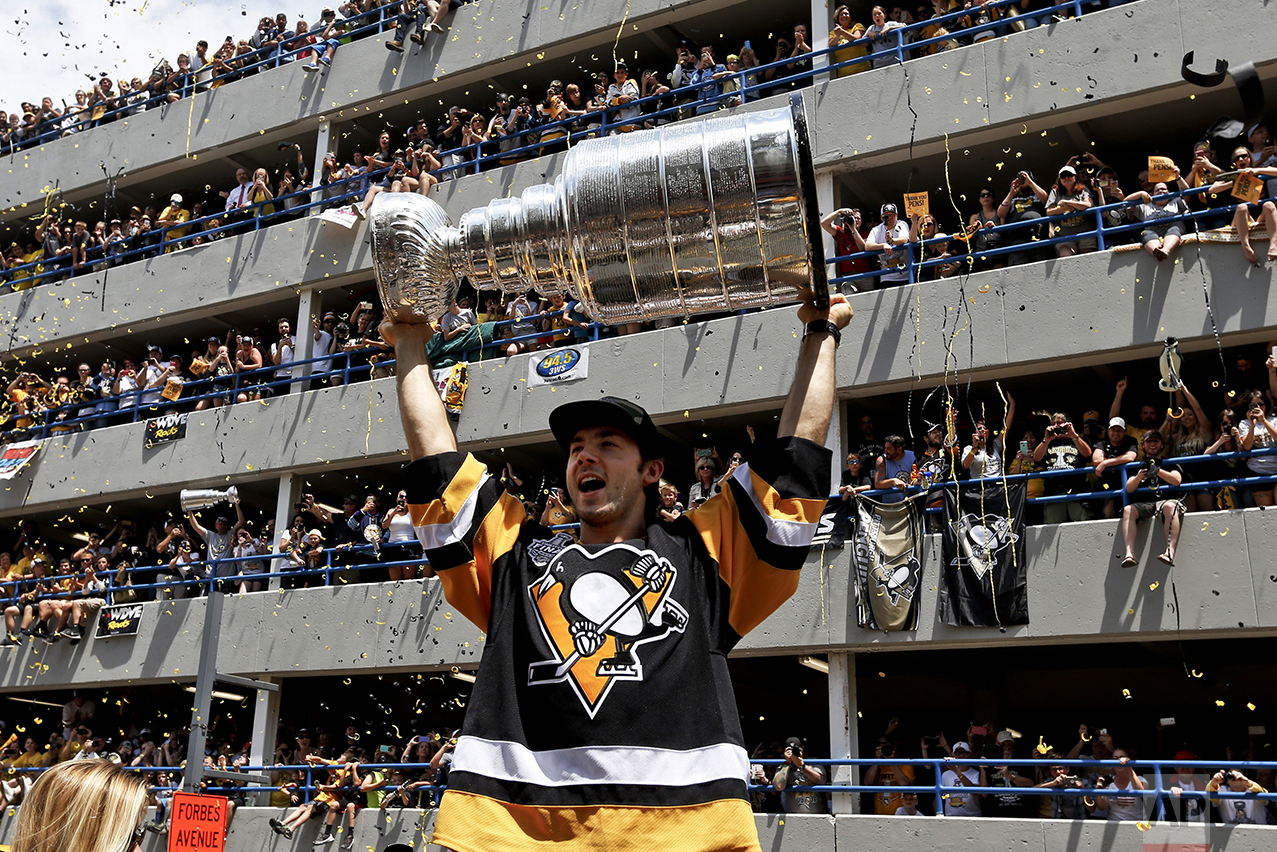  Pittsburgh Penguins' Kris Letang holds the Stanley Cup overhead in front of some of the crowd packing a parking lot along the victory parade route in Pittsburgh, Pa., on June 15, 2016. The Penguins defeated the San Jose Sharks to win the NHL hockey 