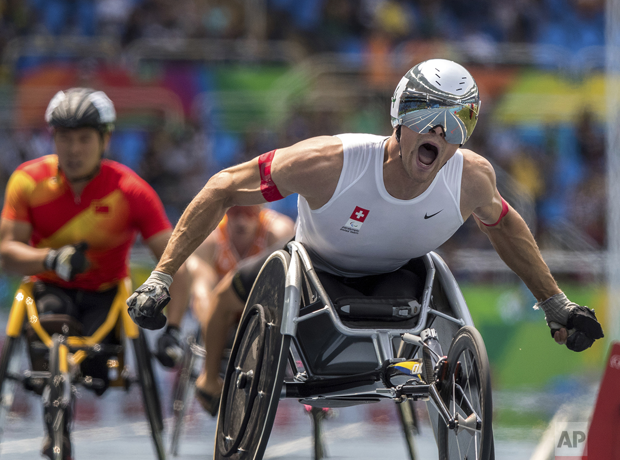  In this photo released by the IOC, wheelchair racer Marcel Hug, of Switzerland, celebrates winning the athletics men's final 800-meter T54 athletics event at Olympic Stadium during the Paralympic Games in Rio de Janeiro, Brazil, on Sept. 15, 2016. (