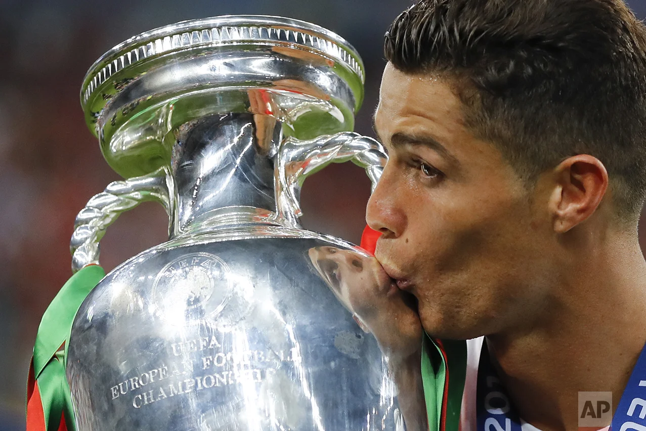 Portugal's Cristiano Ronaldo kisses the trophy at the end of the Euro 2016 final soccer match between Portugal and France at the Stade de France in Saint-Denis, north of Paris, on July 10, 2016. Portugal won 1-0. (AP Photo/Frank Augstein)