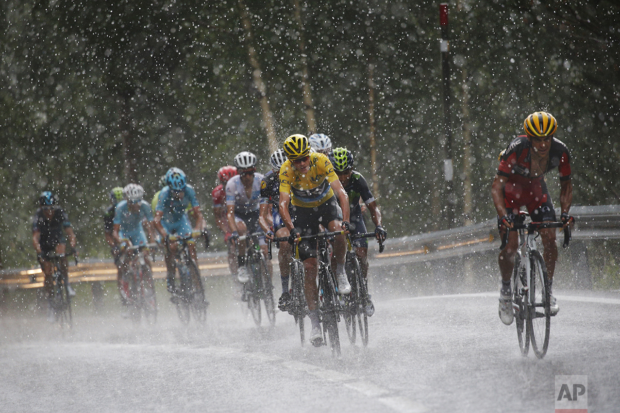  Australia's Richie Porte, right, breaks away from the group with Britain's Chris Froome, wearing the overall leader's yellow jersey, as they climb towards Andorra Arcalis in pouring rain and hail during the ninth stage of the Tour de France cycling 