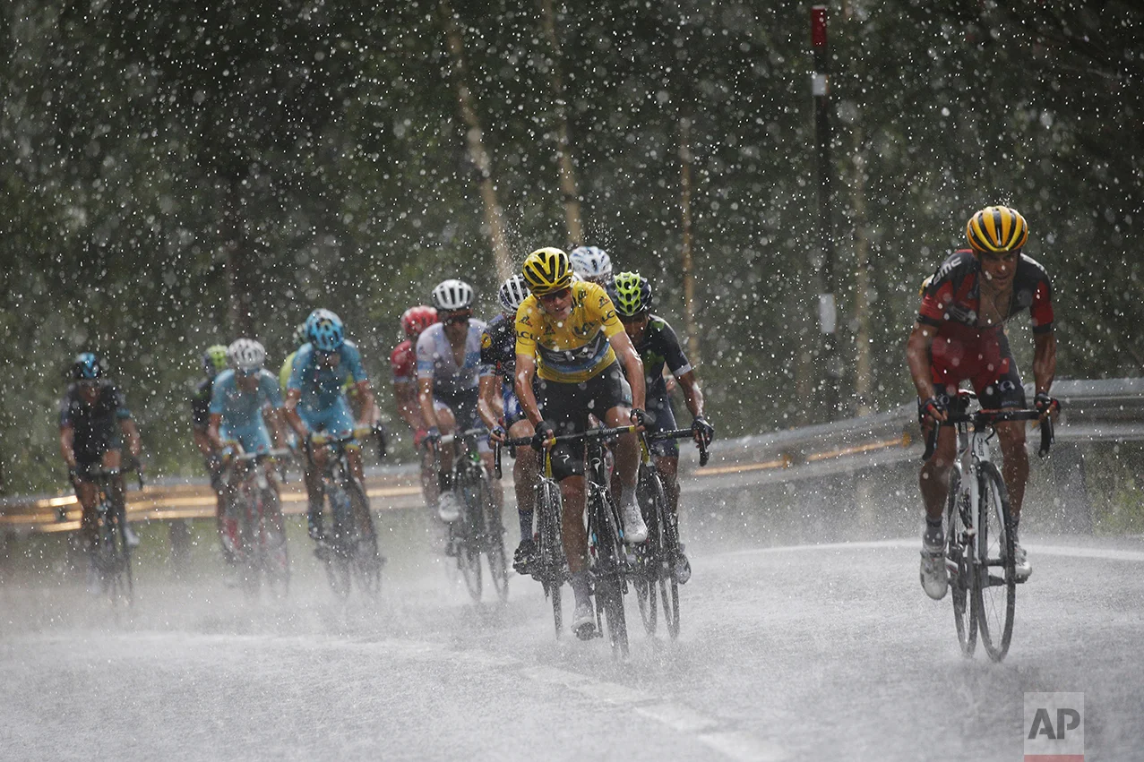 Australia's Richie Porte, right, breaks away from the group with Britain's Chris Froome, wearing the overall leader's yellow jersey, as they climb towards Andorra Arcalis in pouring rain and hail during the ninth stage of the Tour de France cycling race over 184.5 kilometers (114.3 miles) with start in Vielha Val d'Aran, Spain, and finish in Andorra Arcalis, Andorra, on July 10, 2016. (AP Photo/Christophe Ena)