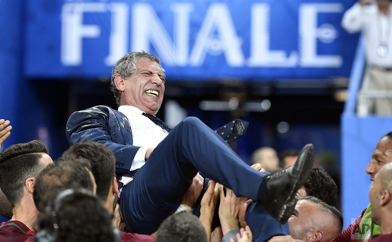  Portugal coach Fernando Santos is lifted by the players after winning the Euro 2016 final soccer match between Portugal and France at the Stade de France in Saint-Denis, north of Paris, on July 10, 2016. (AP Photo/Martin Meissner) 