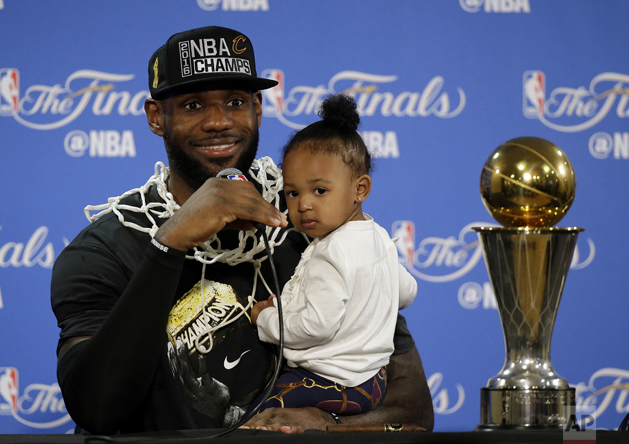  Cleveland Cavaliers' LeBron James answers questions as he holds his daughter Zhuri, during a post-game press conference following Game 7 of basketball's NBA Finals on June 19, 2016, in Oakland, Calif. Cleveland won 93-89. (AP Photo/Eric Risberg) 