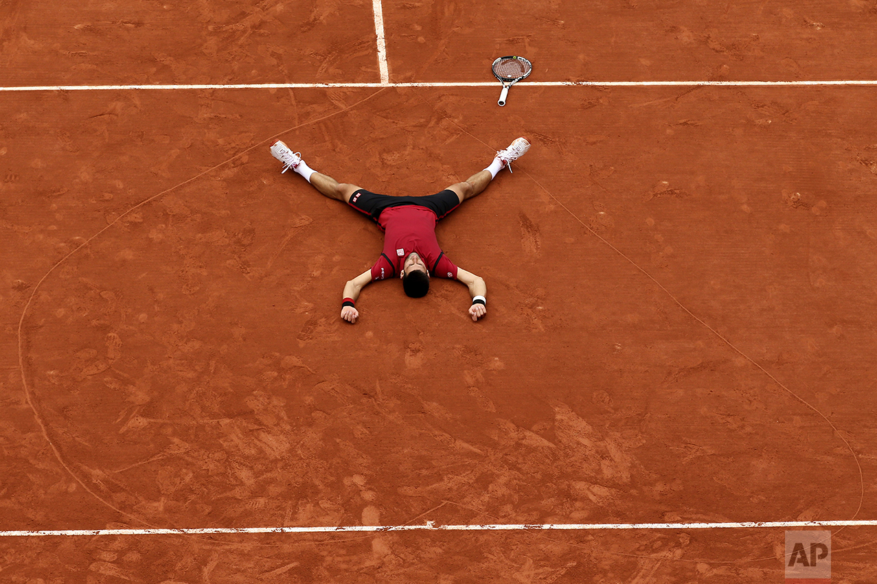  Serbia's Novak Djokovic lies on the clay in a heart he drew after defeating Britain's Andy Murray during their final match of the French Open tennis tournament at the Roland Garros stadium on June 5, 2016, in Paris. Djokovic won 3-6, 6-1, 6-2, 6-4. 