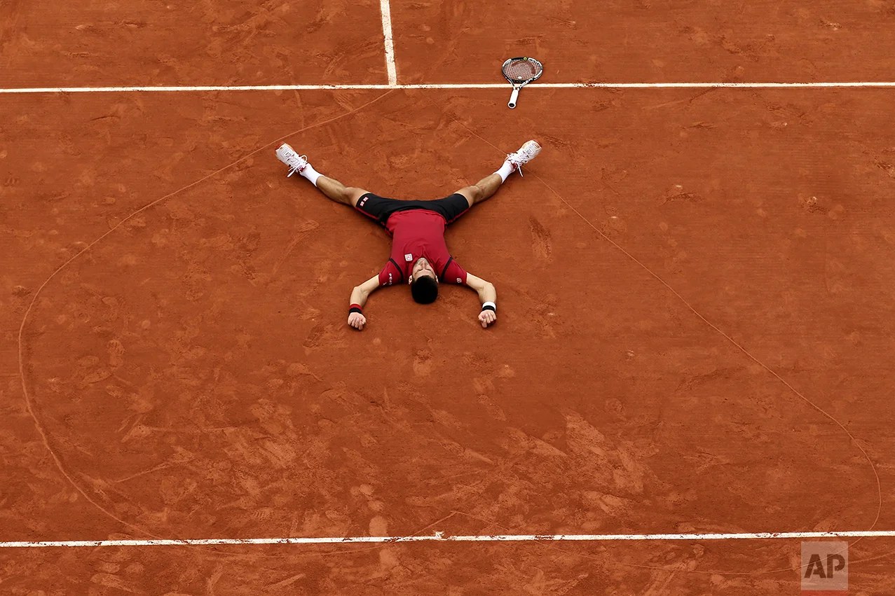 Serbia's Novak Djokovic lies on the clay in a heart he drew after defeating Britain's Andy Murray during their final match of the French Open tennis tournament at the Roland Garros stadium on June 5, 2016, in Paris. Djokovic won 3-6, 6-1, 6-2, 6-4. (AP Photo/David Vincent)
