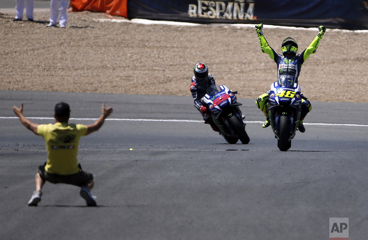  Moto GP rider Valentino Rossi of Italy, right, celebrates after winning the MotoGP race of Spain's Motorcycle Grand Prix at the Jerez race track in Jerez de la Frontera, southern Spain, on April 24, 2016. In the background is Jorge Lorenzo of Spain 