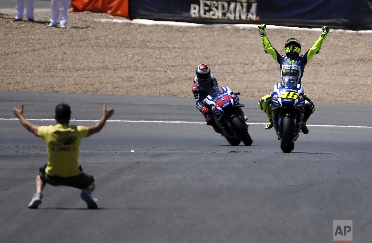 Moto GP rider Valentino Rossi of Italy, right, celebrates after winning the MotoGP race of Spain's Motorcycle Grand Prix at the Jerez race track in Jerez de la Frontera, southern Spain, on April 24, 2016. In the background is Jorge Lorenzo of Spain who finished second. (AP Photo/Miguel Angel Morenatti)