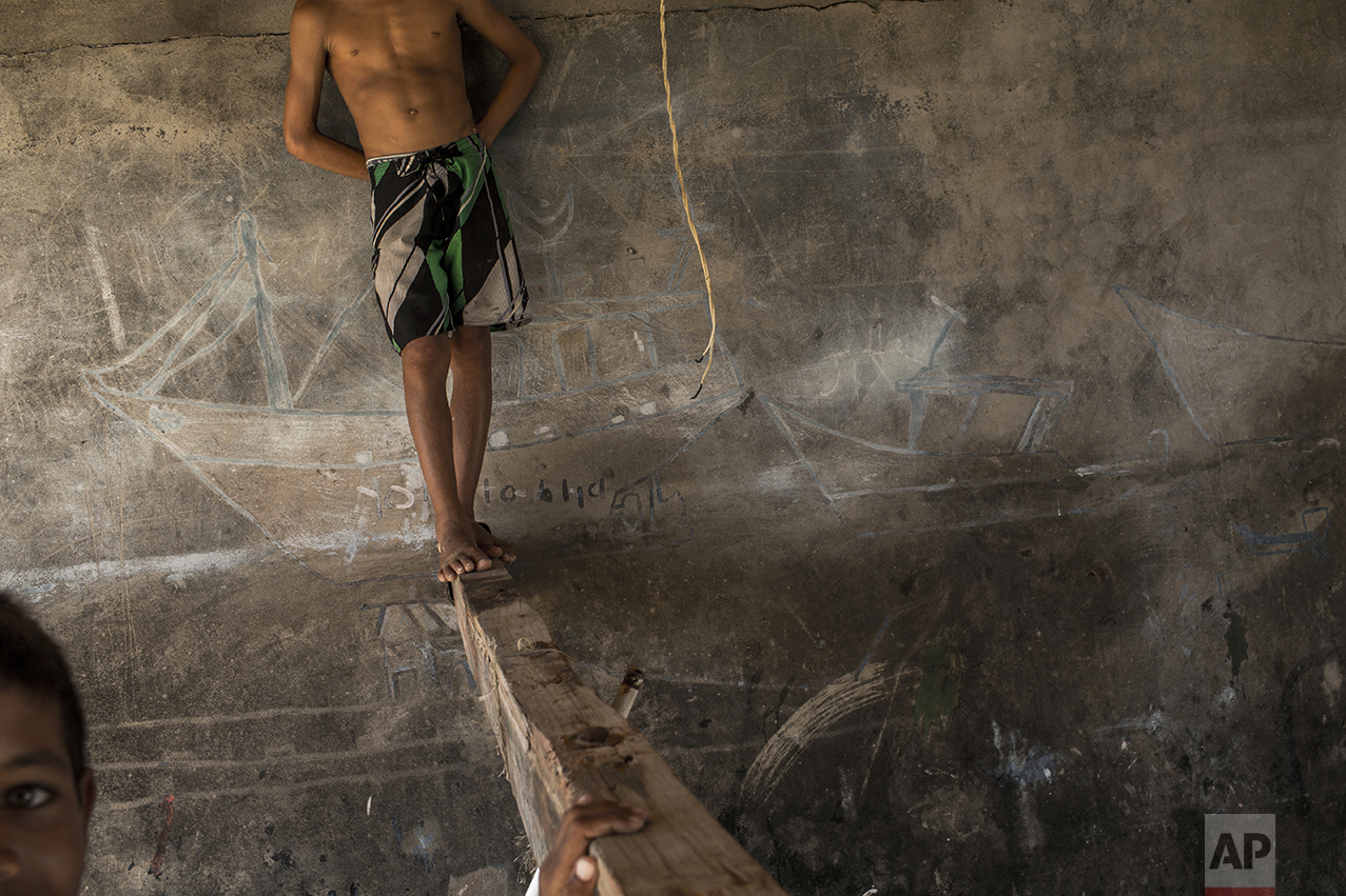 In this Oct. 30, 2016 photo, children play inside a depot used by fishermen to store their nets and repair boats in Punta de Araya, Sucre state, Venezuela. Desperate, Venezuelans are stealing what remains from fatter times, robbing fishing boats of their nets, power generators and outboard motors, making the warm Caribbean sea increasingly a grim free-for-all. (AP Photo/Rodrigo Abd)