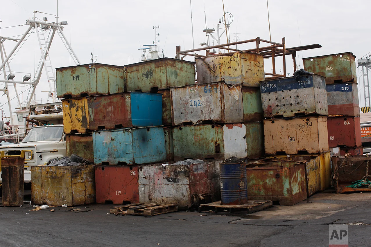 In this Nov. 4, 2016 photo, old fish containers are stored at the state-run fishing company Pescalba in Cumana, Sucre state, Venezuela. On a recent workday, more than half of the company’s fleet bobbed uselessly at the dock, holes gaping where the ships’ decks and sides had rusted open. (AP Photo/Rodrigo Abd)