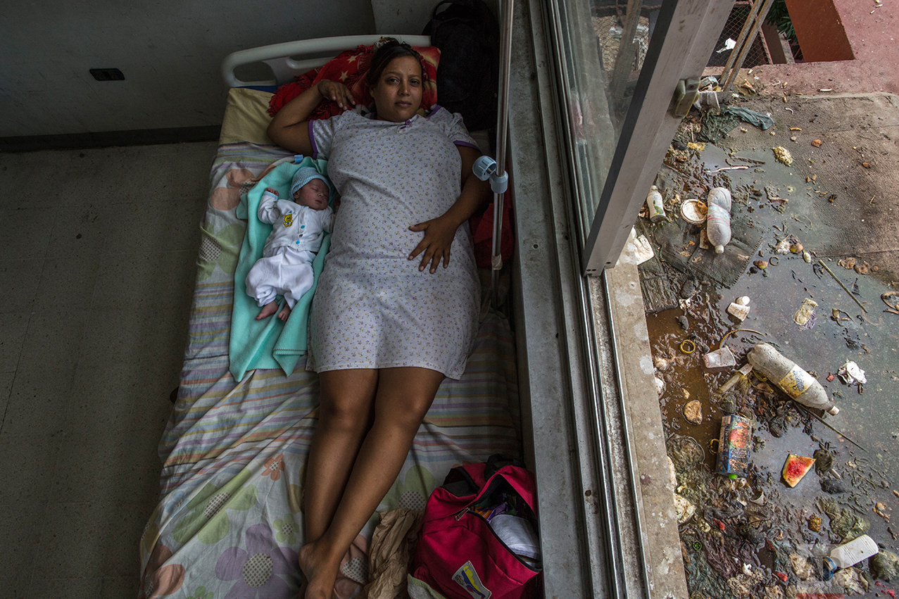 In this Nov. 5, 2016 photo, Virginia Vargas rests with her 1-day-old baby in the maternity ward at the public hospital in Cumana, Sucre state, Venezuela. According to obstetrician Javier Vegas, his hospital lacks basic supplies, so doctors have to wash and reuse materials like sutures, and many new mothers get infections as a result. (AP Photo/Rodrigo Abd)