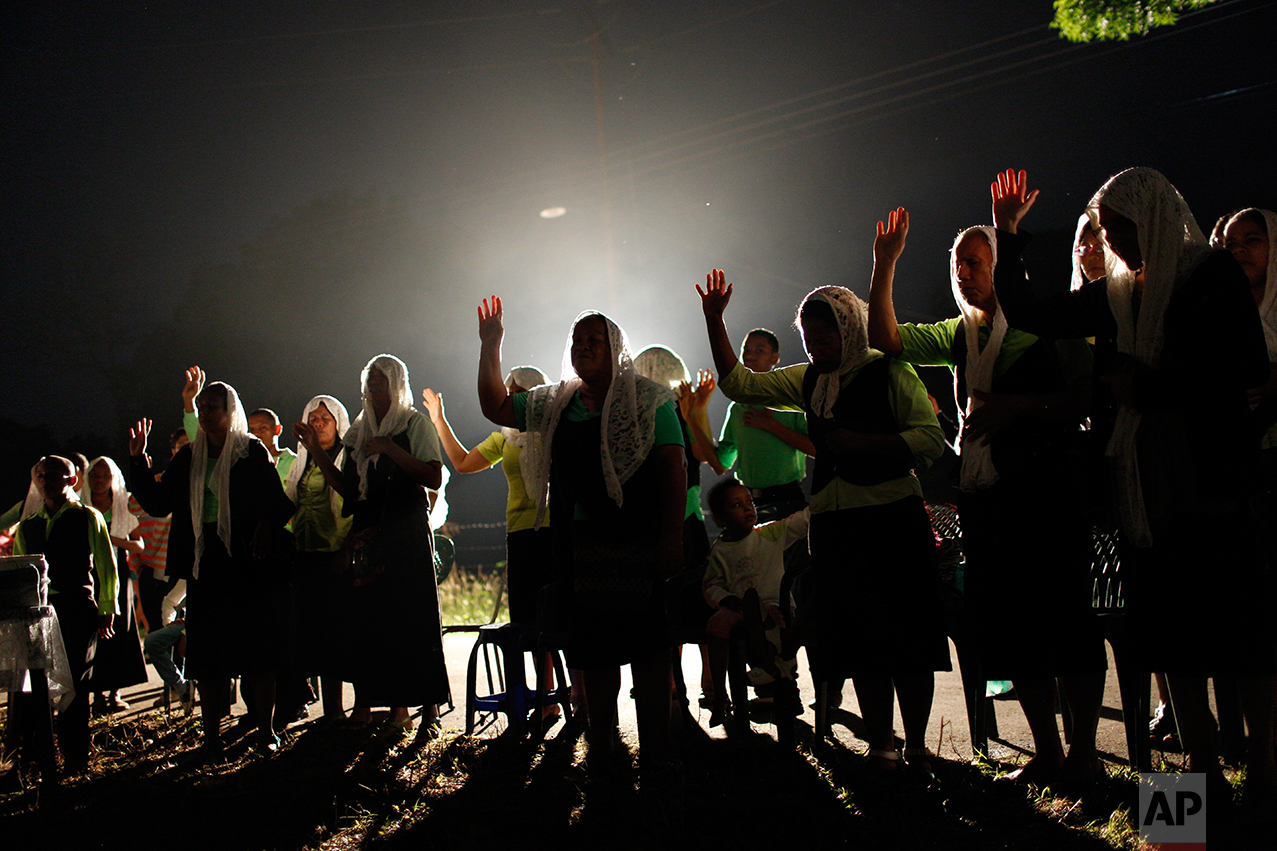 In this Nov. 12, 2016, members of the evangelical church "La Nueva Jerusalen" pray in Cariaco, Sucre state, Venezuela. One civil engineer from Caracas said he moved here two decades ago for a more peaceful life. As the state sinks deeper into chaos, he's thinking of moving back. Caracas is a lifeboat, he said, and the rest of the country is quietly drowning. (AP Photo/Rodrigo Abd)