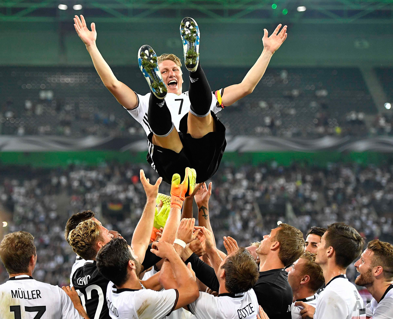  In this Wednesday, Aug. 31, 2016 photo, Germany's national soccer team throws their captain Bastian Schweinsteiger into the air after he played his last match for the national team in Moenchengladbach, Germany. (AP Photo/Martin Meissner) 