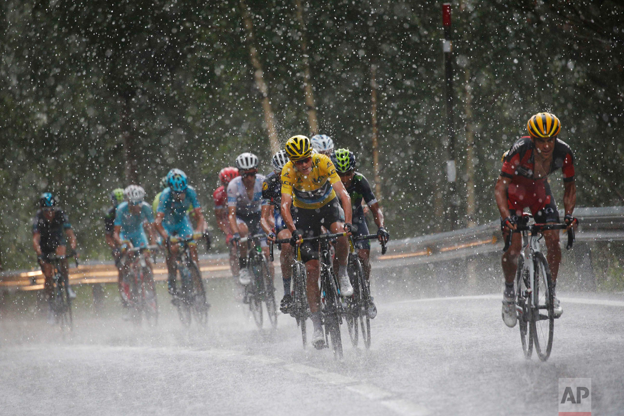  In this Sunday, July 10, 2016 photo, Australia's Richie Porte, right, breaks away from the group with Britain's Chris Froome, wearing the overall leader's yellow jersey, as they climb towards Andorra Arcalis in pouring rain and hail during the ninth