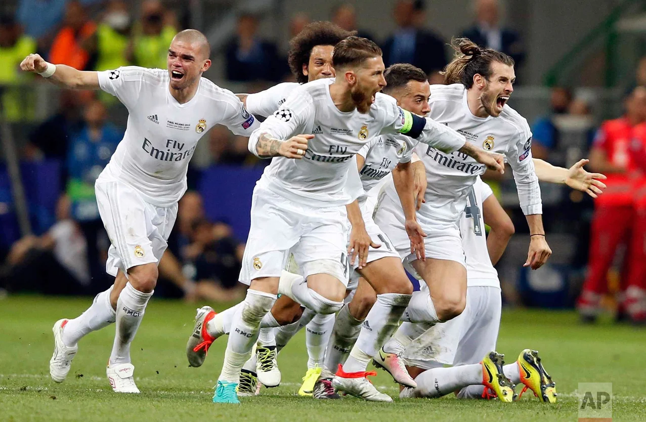 In this Saturday, May 28, 2016 photo, Real Madrid players celebrate after Cristiano Ronaldo scored the winning penalty in a shootout during the Champions League final soccer match between Real Madrid and Atletico Madrid at the San Siro stadium in Milan, Italy. (AP Photo/Antonio Calanni)