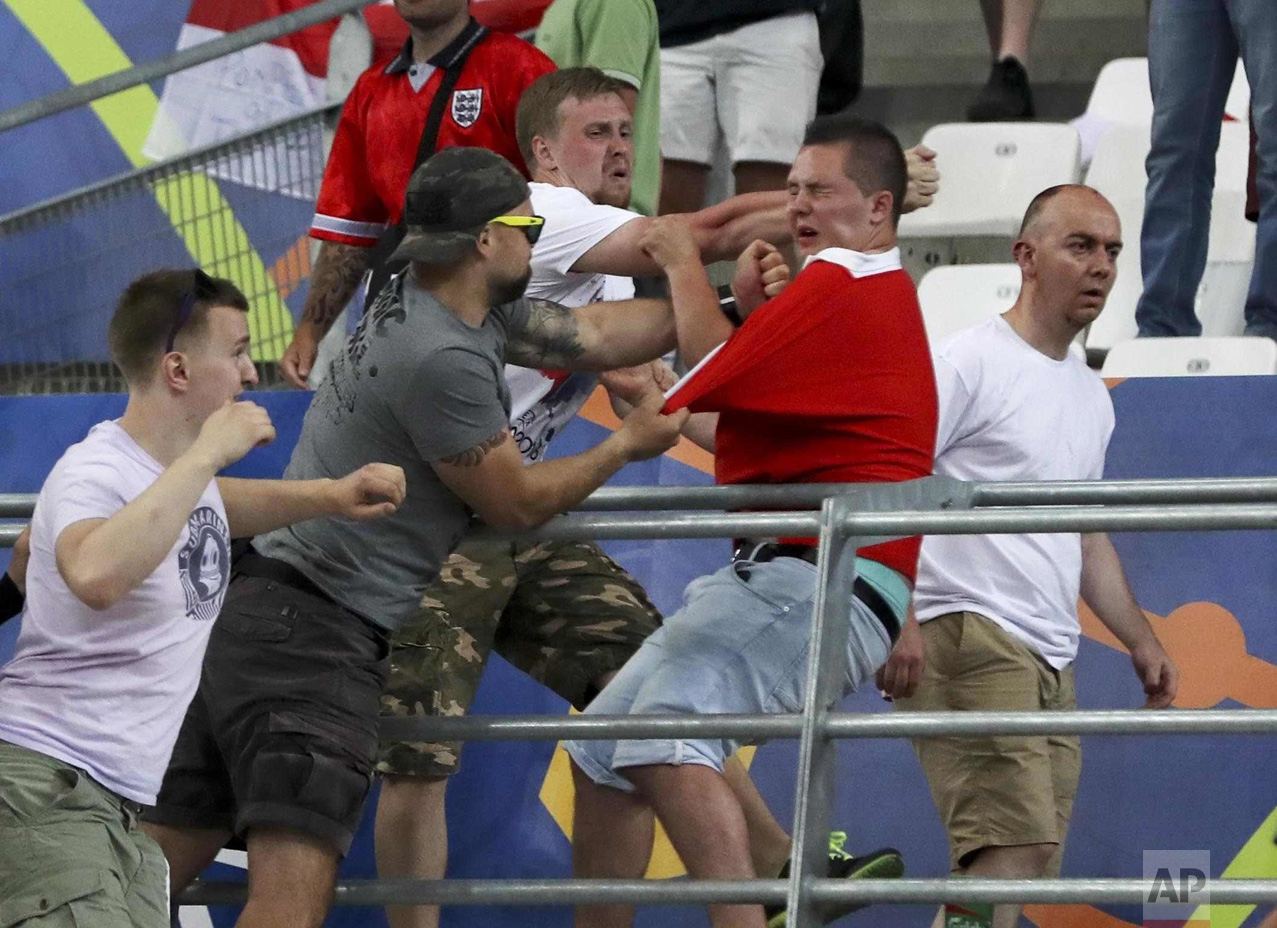  In this Saturday, June 11, 2016 photo, Russian supporters attack an England fan in the stands after the Euro 2016 Group B soccer match between England and Russia, at the Velodrome stadium in Marseille, France. (AP Photo/Thanassis Stavrakis) 