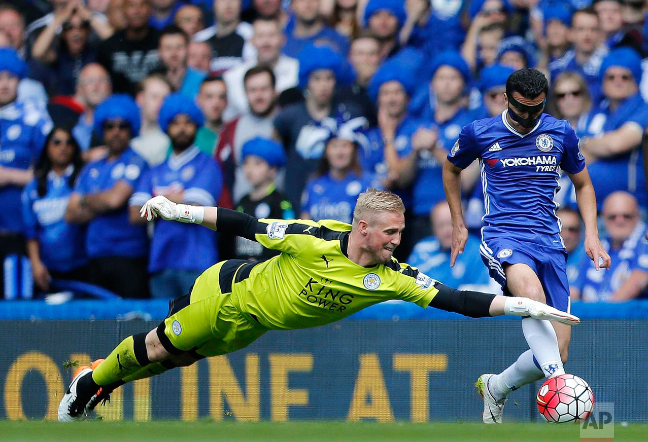  In this Sunday, May 15, 2016 photo, Leicester's goalkeeper Kasper Schmeichel, left, and Chelsea's Pedro challenge for the ball during the English Premier League soccer match between Chelsea and Leicester City at Stamford Bridge stadium in London. (A