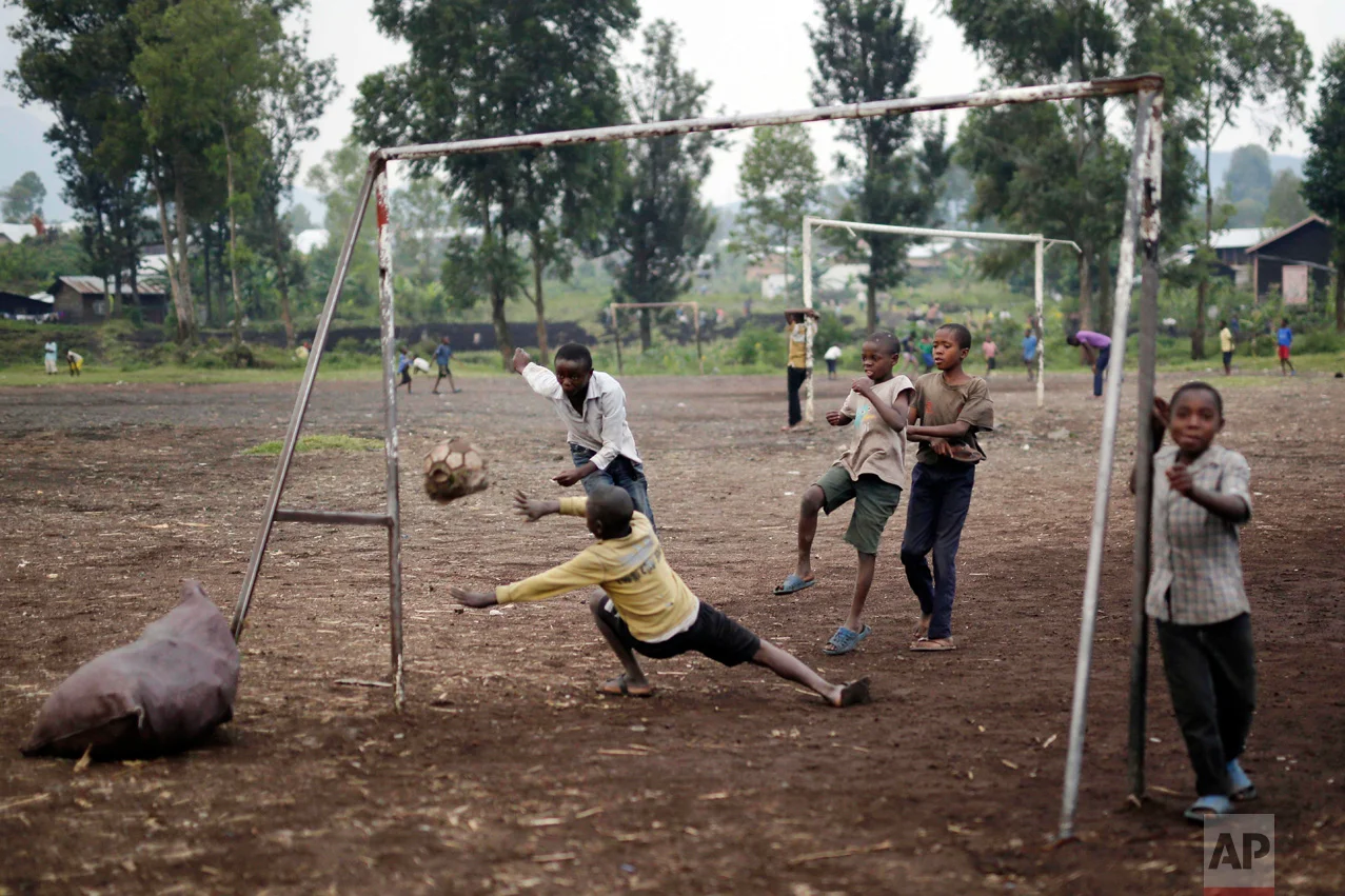 In this Saturday June 18, 2016 photo, Congolese children play soccer on a dirt field in Goma, Democratic Republic of Congo. One goal was scored with the old deflated ball the children use to play with. (AP Photo/Jerome Delay)